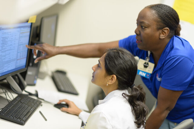 UF Health providers looking at a computer screen