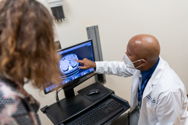 Cancer doctor pointing at a scan on a computer screen