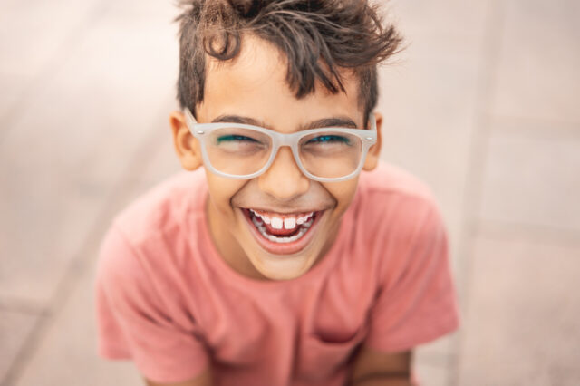 Kid with glasses smiling at camera