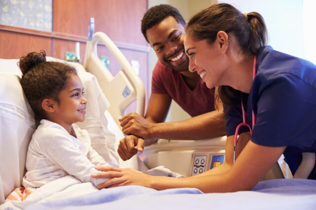 Nurse and parent holding pediatric patient's hand