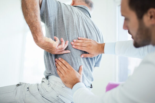 Doctor checking a patient's lower back