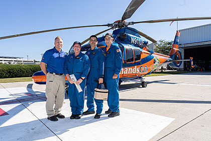 ShandsCair team of four people posing in front of a ShandsCair helicopter
