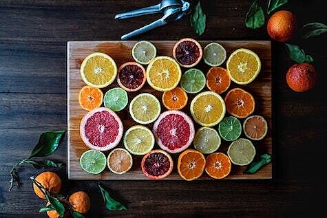 Multicolored citrus slices laid invitingly on a wooden cutting board