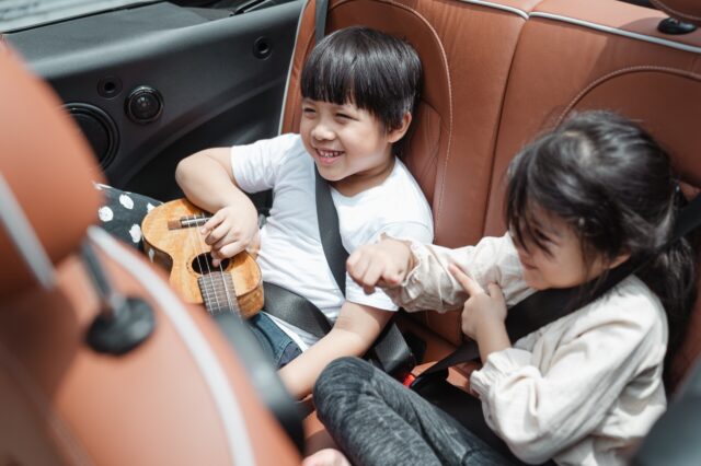Two children in the backseat of a car laughing