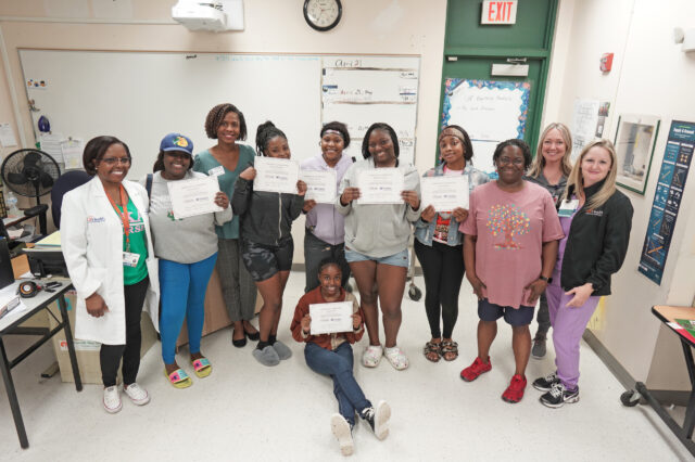 Participants in the UF Health/UF Nursing mentorship program at Eastside High School show their certificates of completion for the program last year. The community mentorship program was supported through a demonstration project initiative that pairs teams of UF Health nurses and College of Nursing faculty to address the complex challenges facing health care.