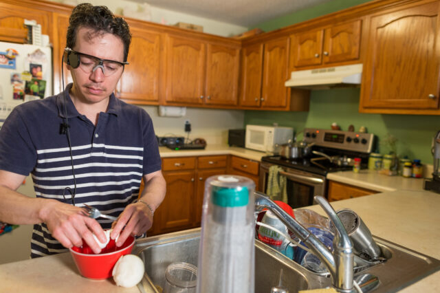 Walfre Lopez uses his artificial-vision system to prepare a meal at his home in Dalton, Georgia. Lopez was the first University of Florida Health patient to receive the Argus II Retinal Prosthesis System during a procedure earlier this year.