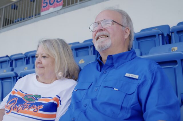 Greg Magruder (right) sits with his wife Karen (left) in the stands at Ben Hill Griffin Stadium.