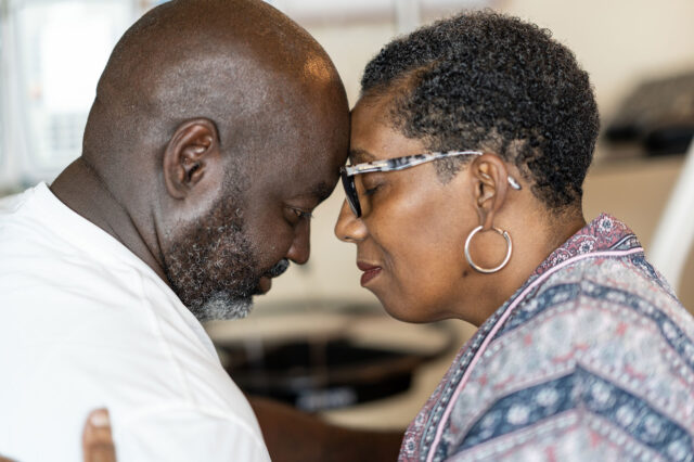 Sandra Davis-Quinney and her husband share a moment of contemplation, resting their foreheads on one another.