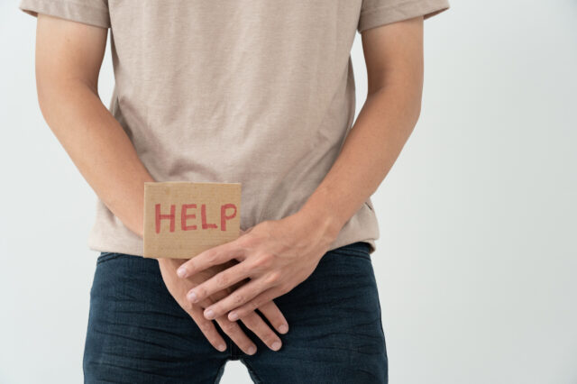 Man holding a help sign over his stomach