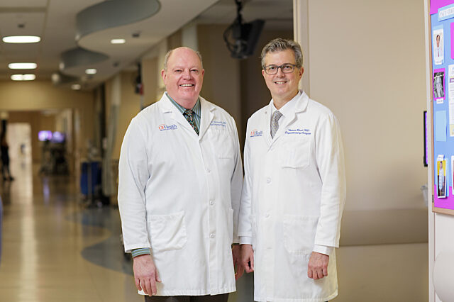 Dr. Forsmark and Dr. Read stand in unison, smiling triumphantly