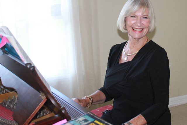 Jane playing piano and smiling