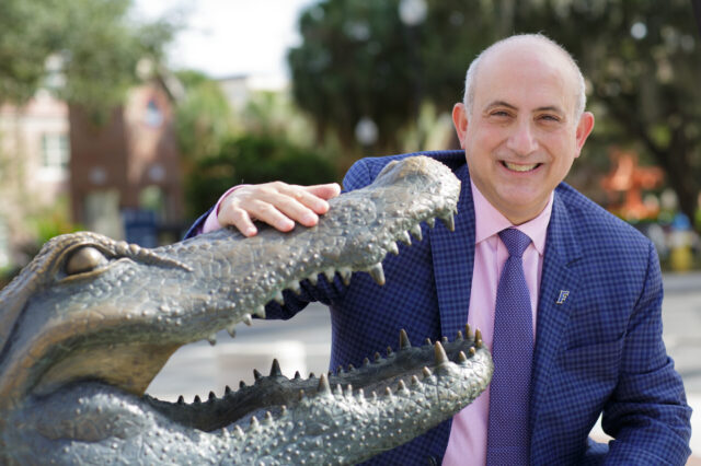 Dr. Licht posing next to the bronze gator statue outside the UF Stadium
