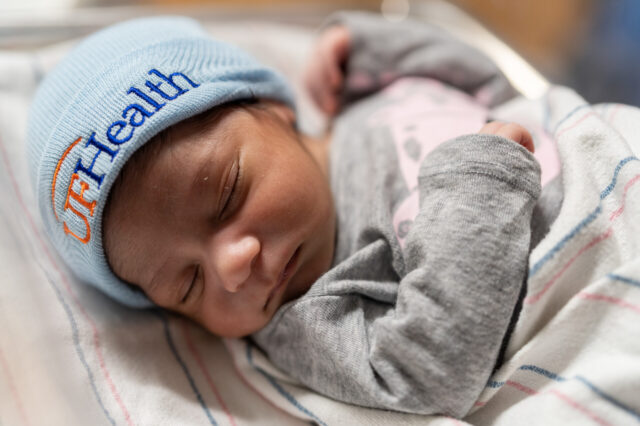 Newborn with UF Heath cap on