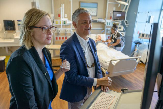 Two people looking at a computer in a patient's room