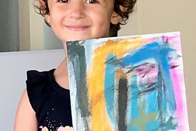 Josie Macchio poses with one of her paintings