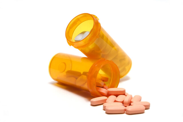 Orange plastic pill bottles with pills.
