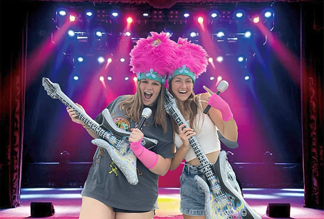 Two Footprints volunteers dressed up as rock stars holding guitars