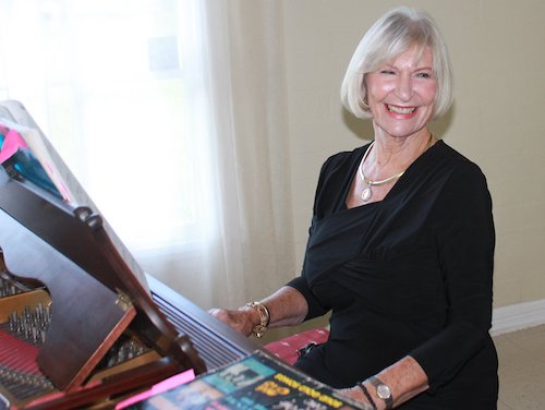 Jane playing piano and smiling