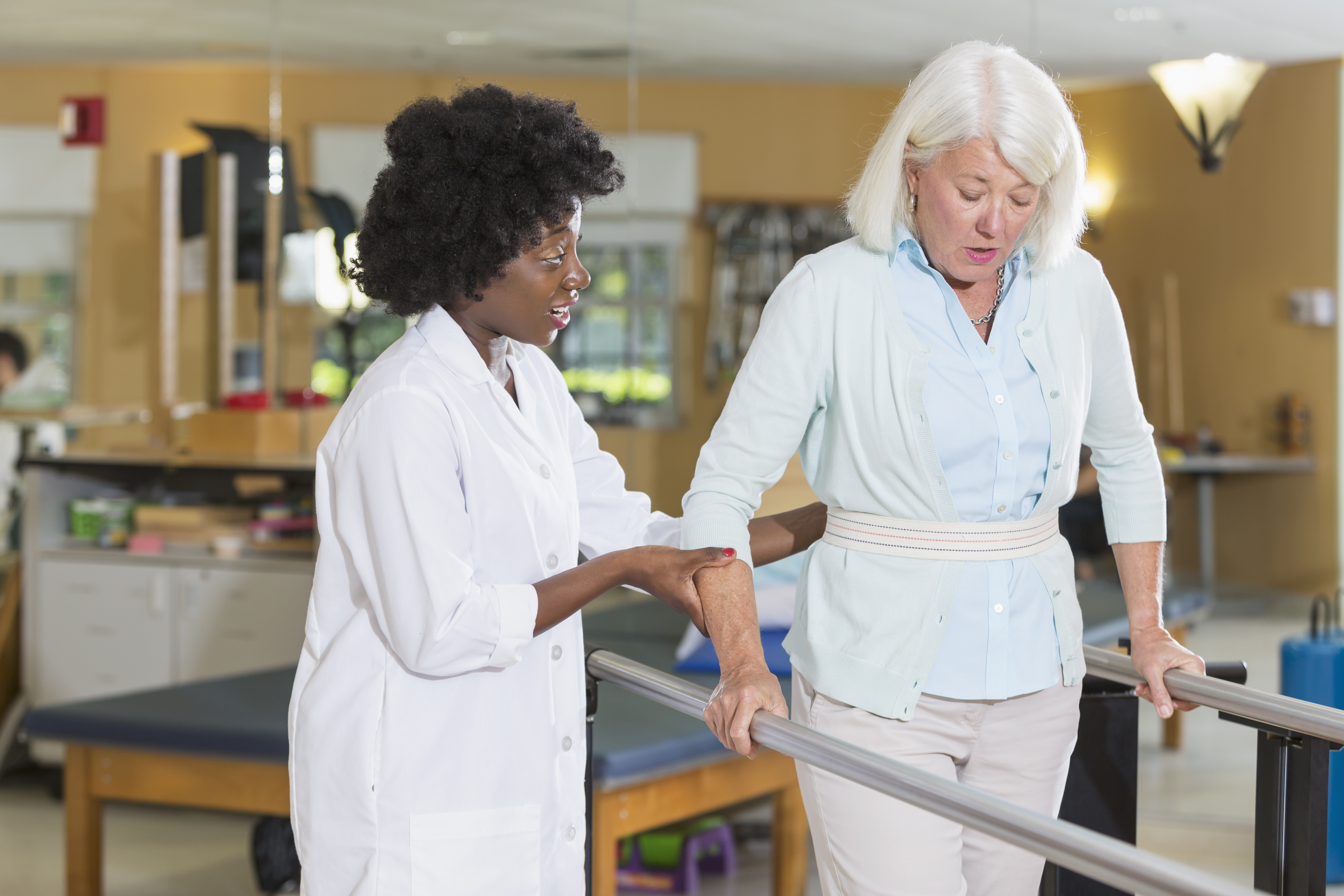 Physical therapist working with female patient on walking gait and balance