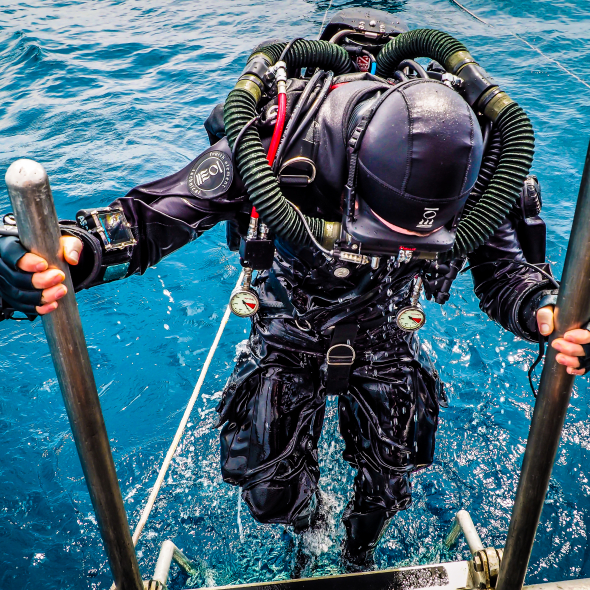 A diver climbs a ladder up out of the water