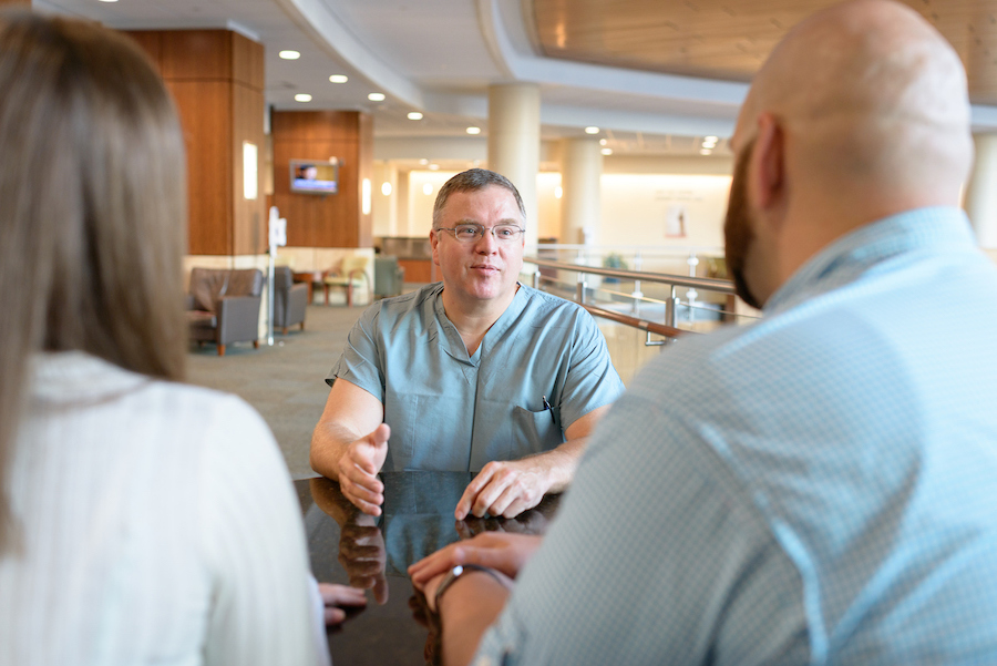 Dr. Paul Crispen speaking to a male patient and his spouse