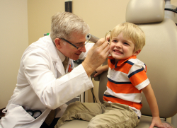 Patrick Antonelli, M.D., co-author of a study showing quinolone ear drops appear to heighten the risk of a perforated ear drum, examines a patient.