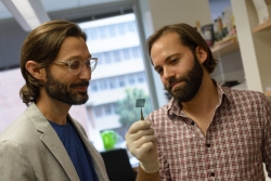 Benjamin G. Keselowsky, Ph.D., an associate professor in the J. Crayton Pruitt Family Department of Biomedical Engineering (left) and Matthew R. Carstens, Ph.D., a post-doctoral associate in Keselowsky’s laboratory, look at a microarray they developed. The device makes chemotherapy treatments more personalized, efficient and affordable. 