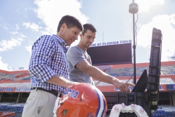 Dr. james Clugston and Matt Graham, coordinator for the head impact telemetry system at UF, set up the system inside Ben Hill Griffin Stadium. The HITS system allows team physicians to monitor hits players receive on the field using sensors placed inside their helmets. 