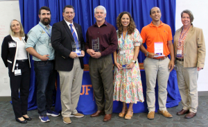 At far left, Dr. Dana Zimmel, dean of the UF College of Veterinary Medicine, stands with the college's 2022 Distinguished Award winners: Dr. Eric Hostnik, Dr. Rick Sutliff, Dr. Dan Lewis, Dr. Erin Porter and Dr. Jacob Vencil. At far right is Dr. Audrey Kelleman, chair of the college's Distinguished Awards committee.