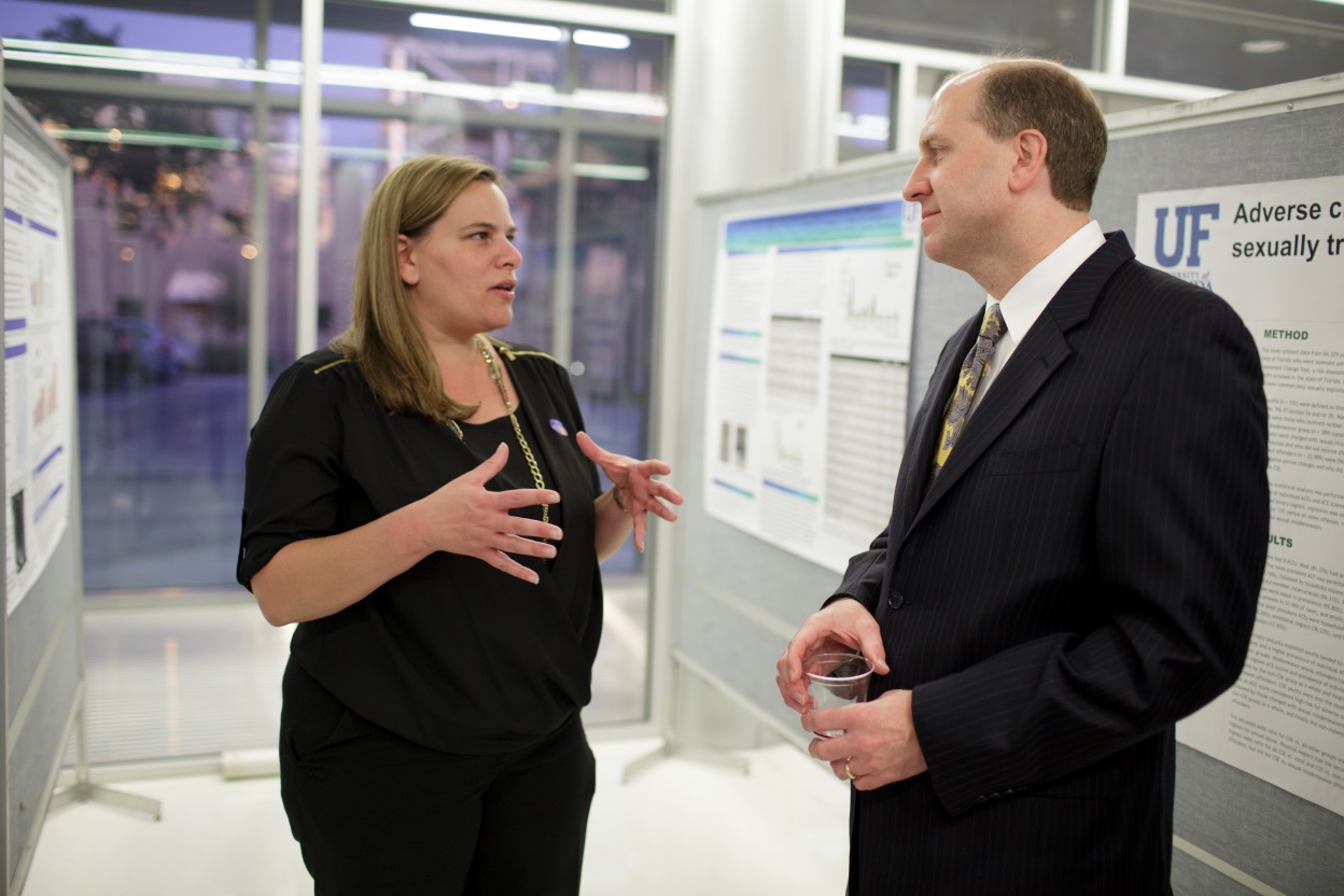 Gina Eubanks, a doctoral student in the Department of Health Outcomes and Policy, discusses her research with Bill Hogan, M.D., M.S., at ICHP’s annual research event in November.