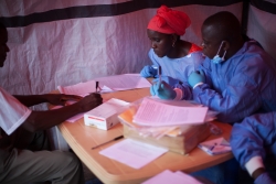 WHO/S. Hawkey-Nene Aminata Diallo and Gamou Saiman Gaston, from the World Health Organization Ebola vaccination team, carefully go through the consent process with a participant in the Ebola vaccine trial. 