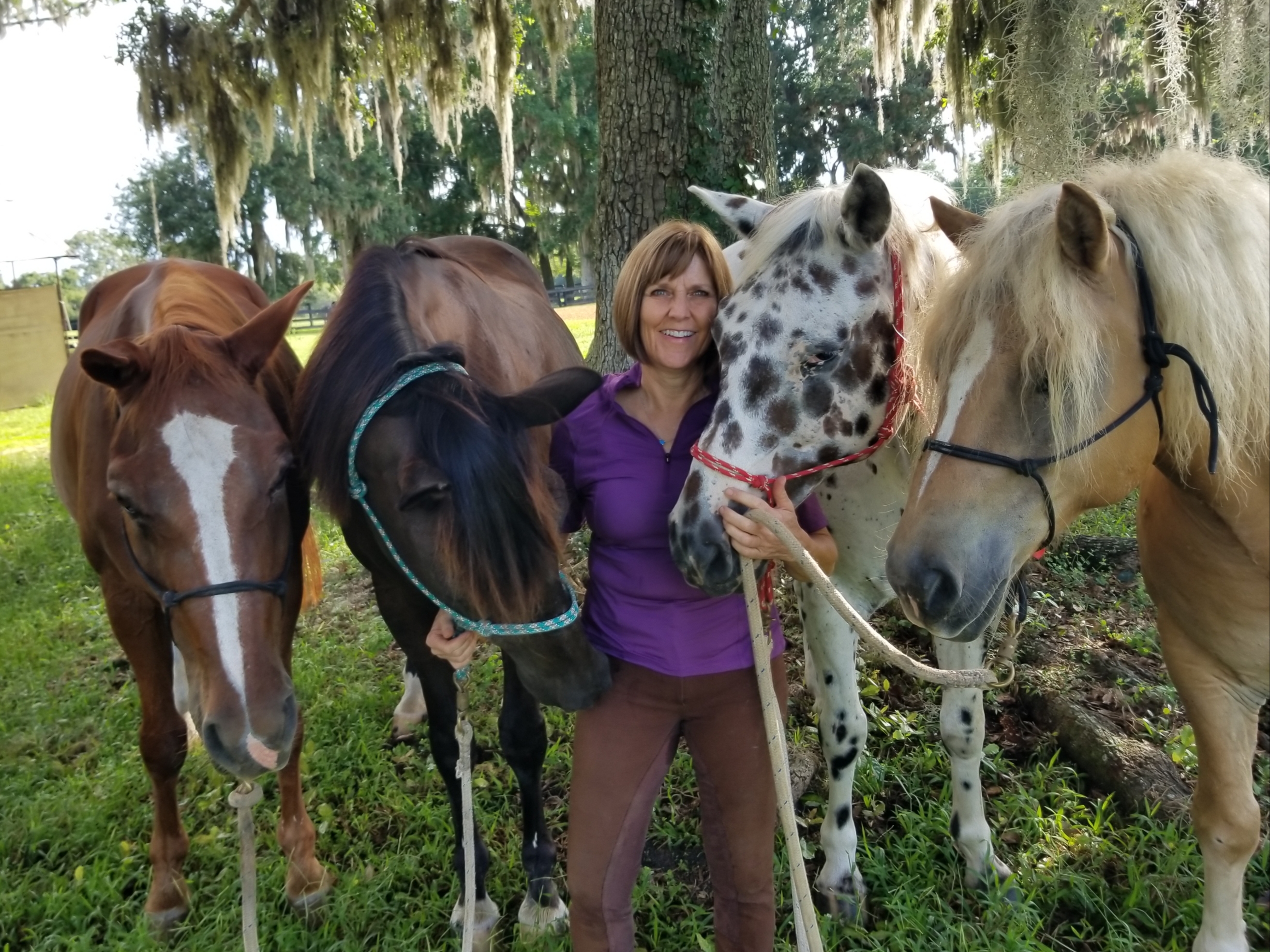 woman smiling with four horses