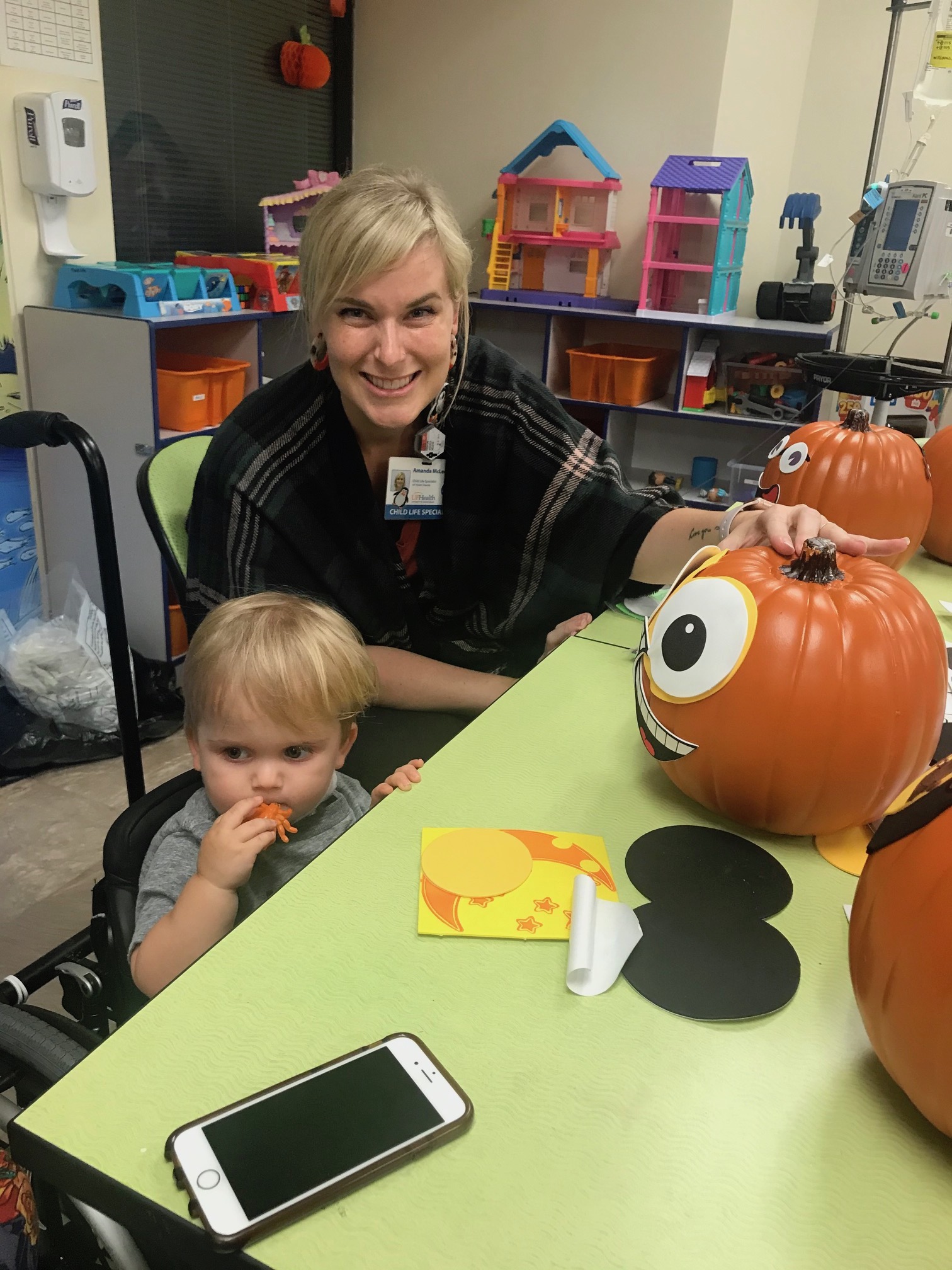 Child life staff member decorating a pumpkin with a pediatric patient