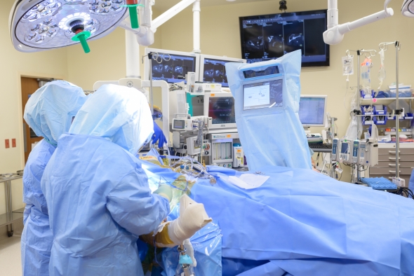 Larry D. Waldrop, M.D., on the right, and a surgical technician work during the opening minutes of a May 31 shoulder replacement surgery for Mercia Reid, 74, a Gainesville woman with severe arthritis. The surgery involved a new technology allowing computer-assisted navigation of the patient’s shoulder using CT scan images.
