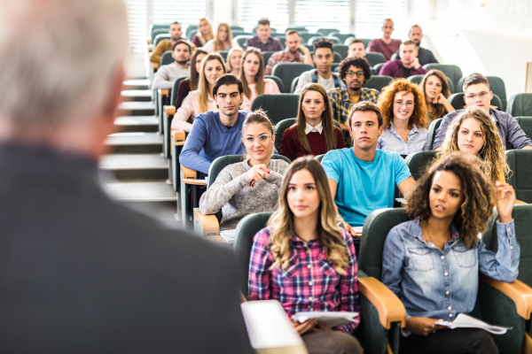 Large group of college students listening to their professor on a class.