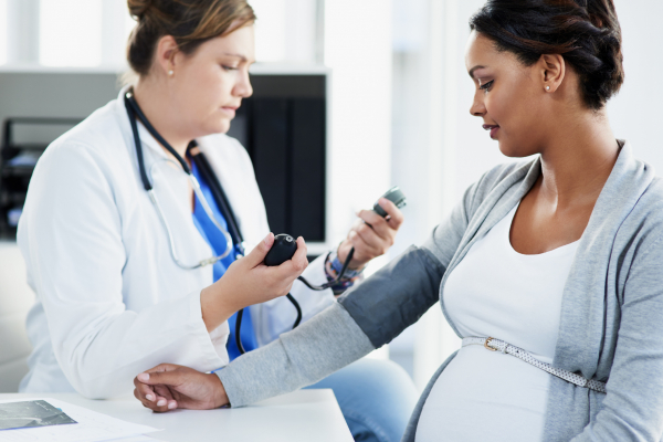 Physician checking the blood pressure of a pregnant patient