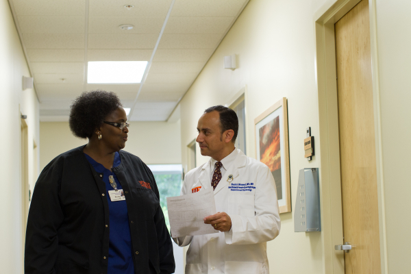 Nash Moawad, M.D., speaking with a fellow staff member.