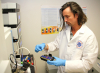 Researcher handles test vials for study.