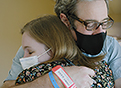Rob Rushin, a T-cell lymphoma patient, hugs Sarah Wheeler, a clinical pharmacy specialist and member of his care team.